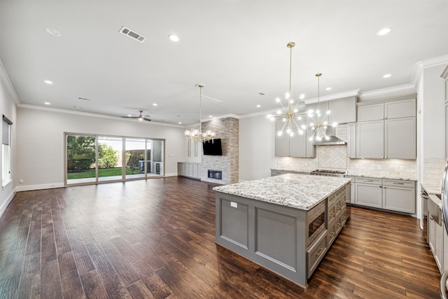 kitchen featuring pendant lighting, a large island, dark wood-type flooring, and gray cabinetry