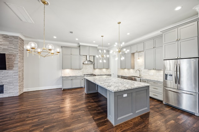 kitchen featuring stainless steel refrigerator with ice dispenser, dark hardwood / wood-style flooring, pendant lighting, gray cabinets, and a kitchen island