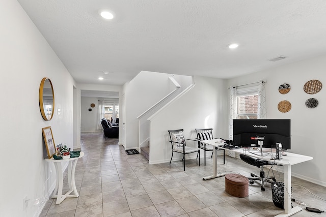 home office featuring light tile patterned floors and a textured ceiling