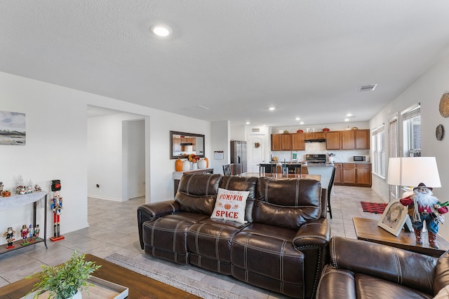 living room with light tile patterned flooring and a textured ceiling