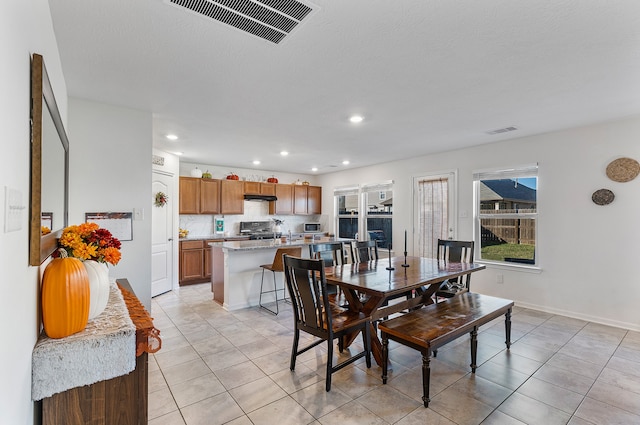 tiled dining space with a textured ceiling