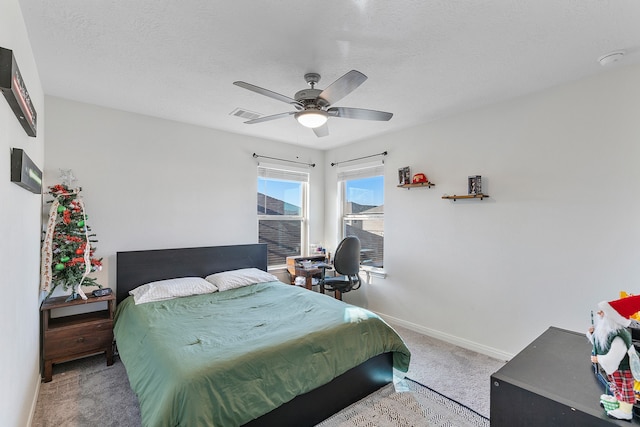 bedroom featuring ceiling fan, carpet, and a textured ceiling