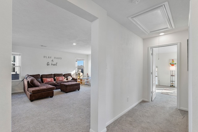 carpeted living room featuring a wealth of natural light and a textured ceiling