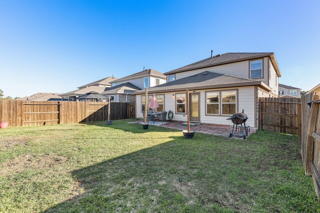 rear view of property with a yard and a patio