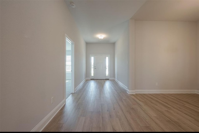 corridor with light hardwood / wood-style floors