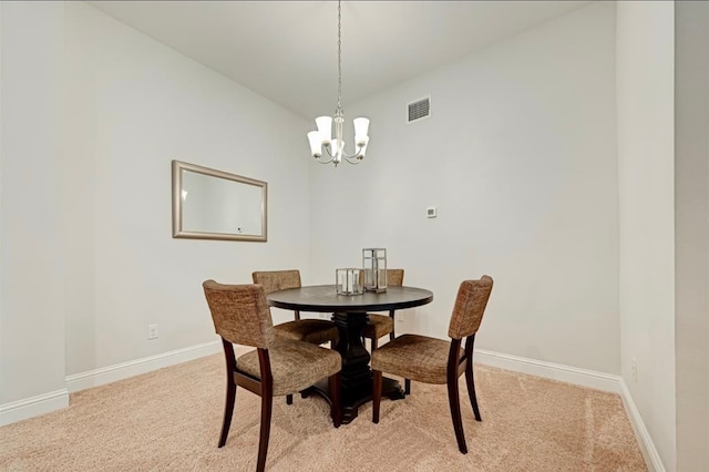 carpeted dining room with a notable chandelier