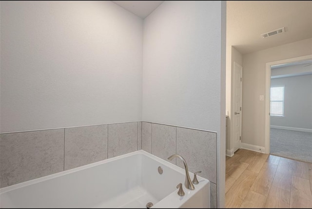 bathroom featuring hardwood / wood-style floors and a bathing tub