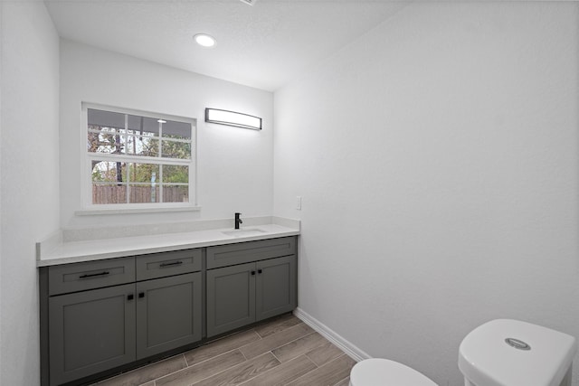 bathroom featuring hardwood / wood-style flooring, vanity, and toilet