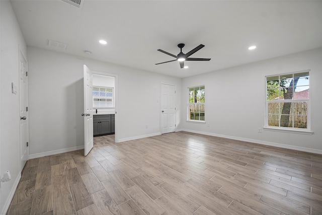 spare room with ceiling fan, plenty of natural light, and light hardwood / wood-style floors