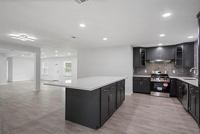 kitchen with a center island, stainless steel appliances, light hardwood / wood-style floors, and sink