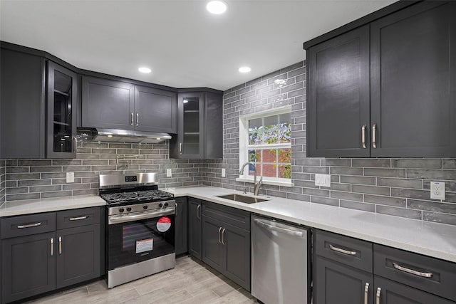 kitchen featuring decorative backsplash, sink, light hardwood / wood-style flooring, and appliances with stainless steel finishes