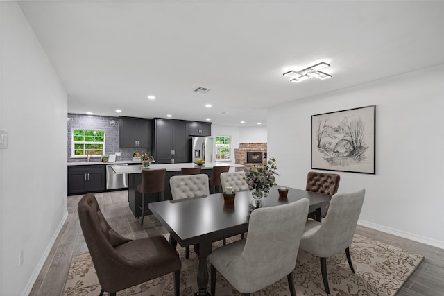 dining area with a fireplace and light hardwood / wood-style floors