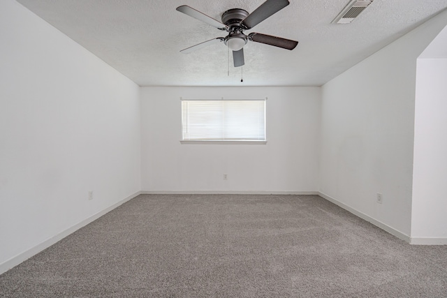 empty room featuring a textured ceiling, light colored carpet, and ceiling fan