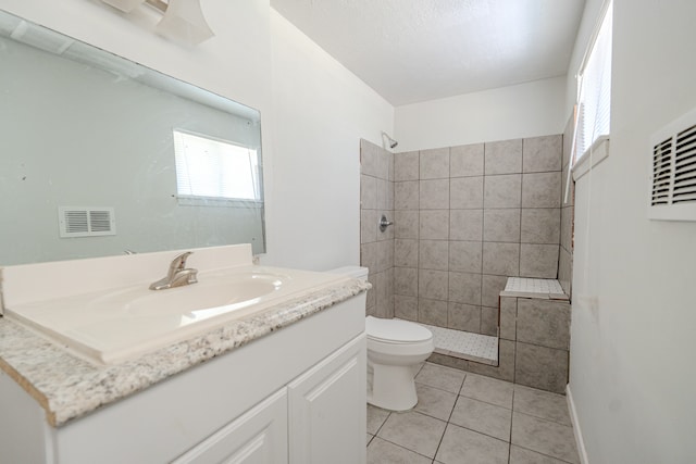 bathroom featuring tile patterned flooring, vanity, toilet, and plenty of natural light