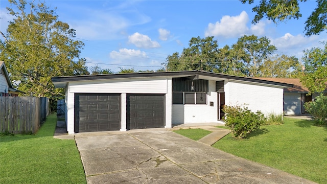 single story home featuring a garage and a front lawn