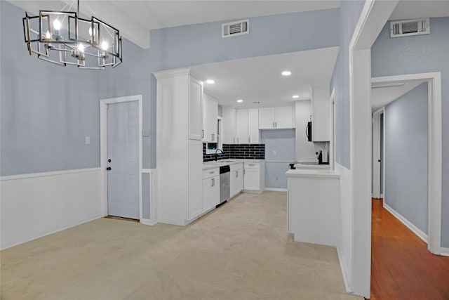 kitchen featuring stainless steel dishwasher, pendant lighting, a chandelier, light hardwood / wood-style floors, and white cabinetry