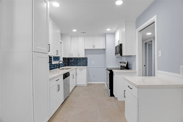 kitchen featuring light stone countertops, appliances with stainless steel finishes, sink, light tile patterned floors, and white cabinets