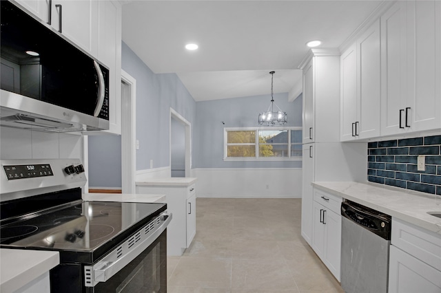 kitchen featuring decorative backsplash, white cabinets, stainless steel appliances, and vaulted ceiling