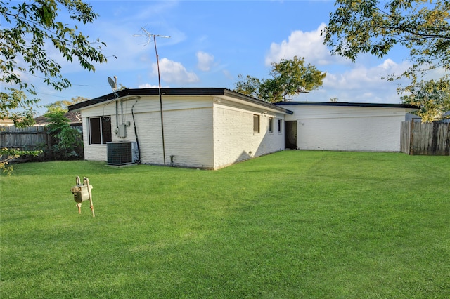 back of house with a yard and central AC unit