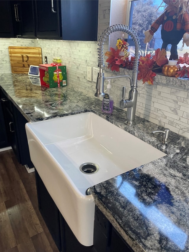 kitchen with stone counters, dark hardwood / wood-style floors, tasteful backsplash, and sink