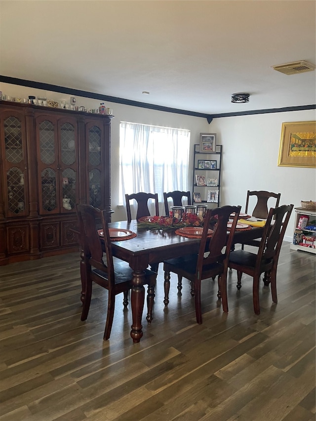 dining room featuring dark hardwood / wood-style flooring and crown molding