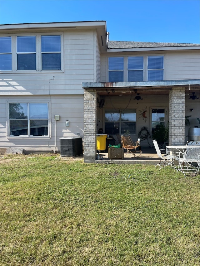 rear view of property featuring central AC unit, ceiling fan, a yard, and a patio