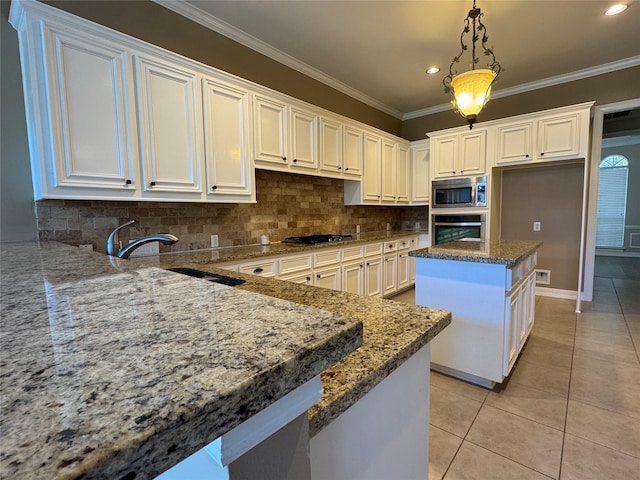 kitchen featuring appliances with stainless steel finishes, decorative light fixtures, a center island, light tile patterned floors, and light stone counters