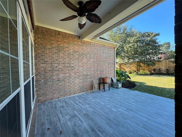 wooden deck with ceiling fan and a lawn