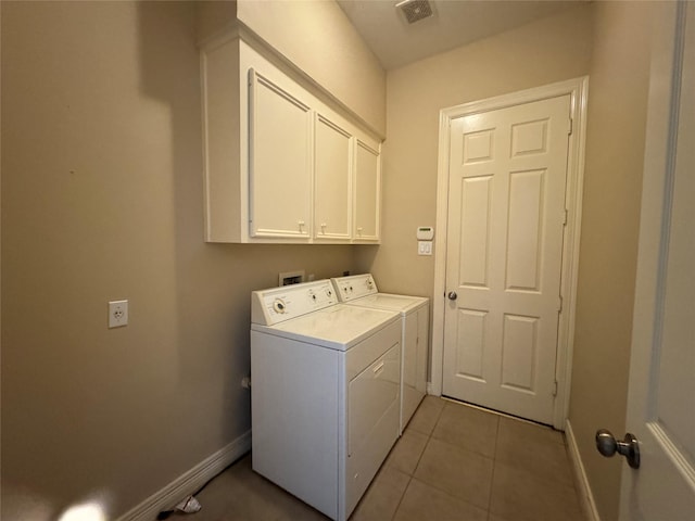 laundry room with washer and dryer, cabinets, and light tile patterned flooring