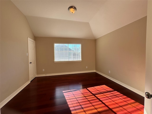 empty room featuring dark hardwood / wood-style flooring and lofted ceiling