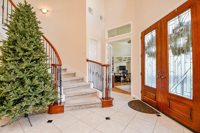 tiled foyer featuring a high ceiling and french doors