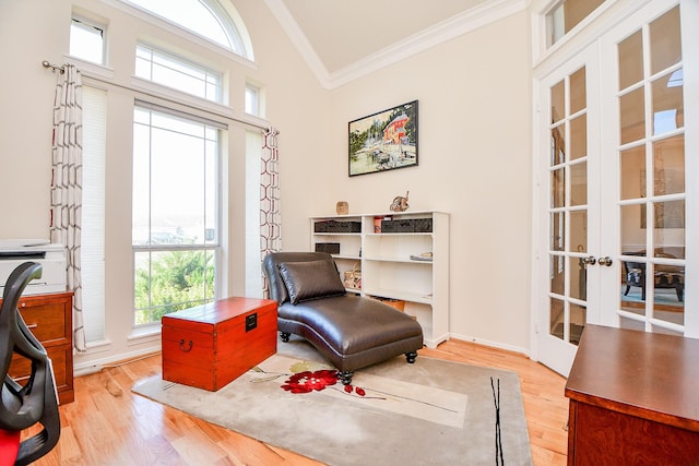 living area featuring french doors, light hardwood / wood-style floors, and crown molding