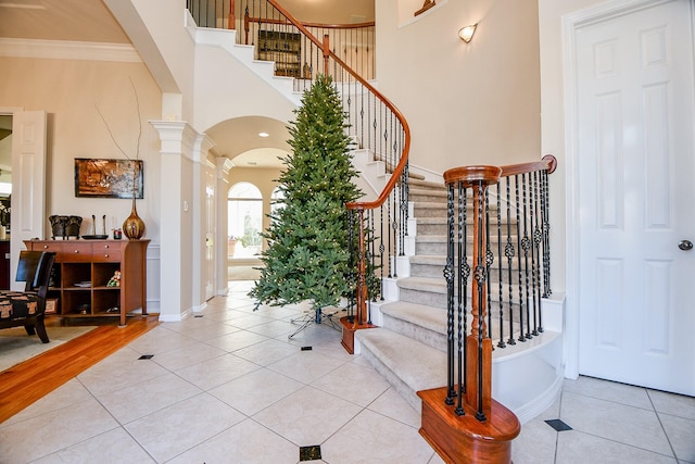 tiled entrance foyer with ornamental molding and ornate columns