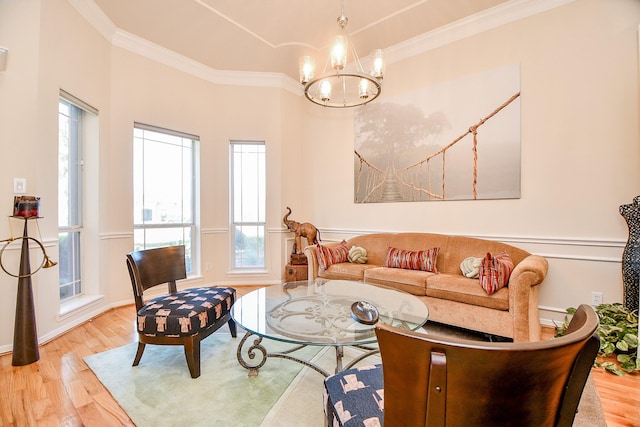 living room featuring a wealth of natural light, ornamental molding, light hardwood / wood-style floors, and a notable chandelier