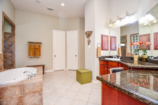 bathroom featuring vanity, tiled bath, and tile patterned floors