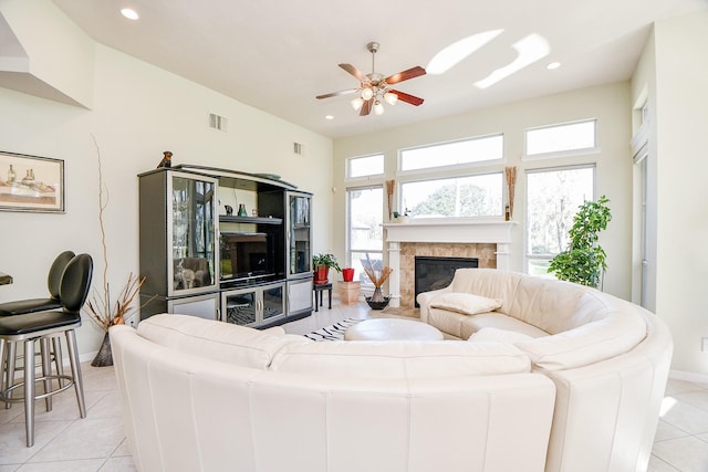 tiled living room featuring a tiled fireplace and ceiling fan