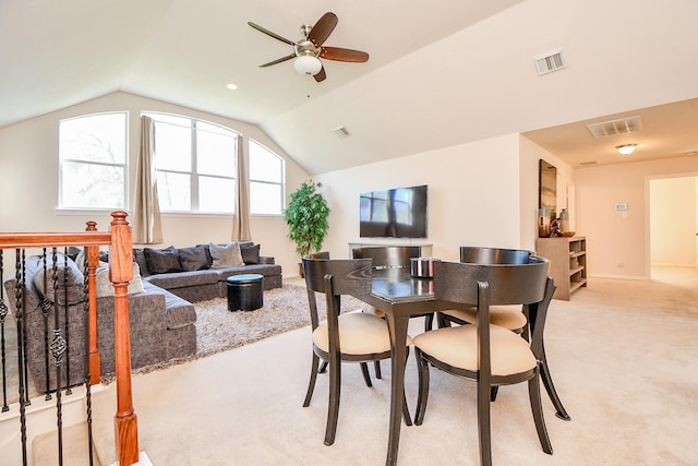 carpeted dining area with ceiling fan and vaulted ceiling