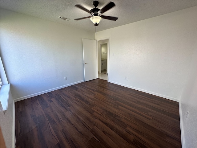 spare room with ceiling fan, dark wood-type flooring, and a textured ceiling