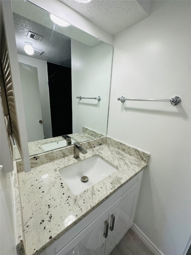 bathroom with a textured ceiling and vanity