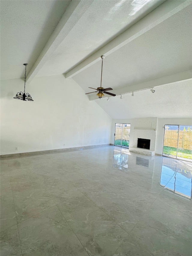 unfurnished living room with vaulted ceiling with beams, a brick fireplace, ceiling fan, and a healthy amount of sunlight