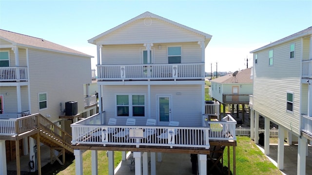 back of property with a lawn, central air condition unit, and a wooden deck