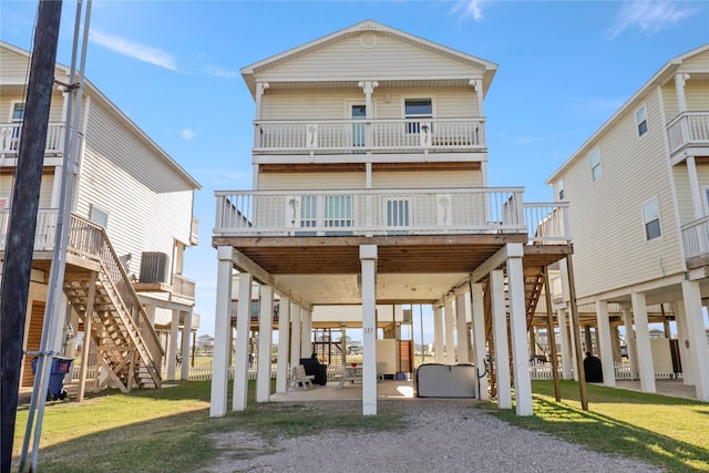 rear view of house with a lawn and a balcony