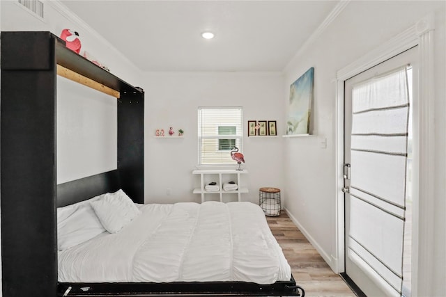 bedroom featuring crown molding and light hardwood / wood-style flooring