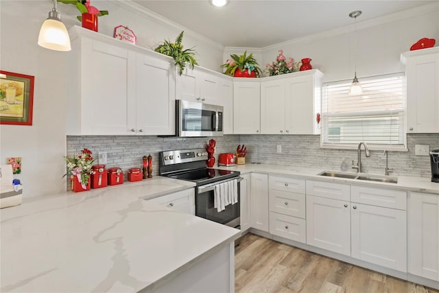 kitchen with crown molding, sink, appliances with stainless steel finishes, decorative light fixtures, and white cabinetry