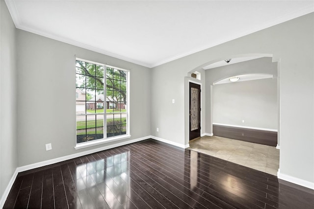 empty room with wood-type flooring and crown molding