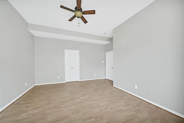 empty room with ceiling fan and light hardwood / wood-style flooring