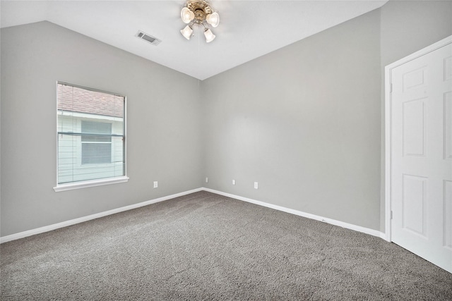 carpeted empty room with vaulted ceiling