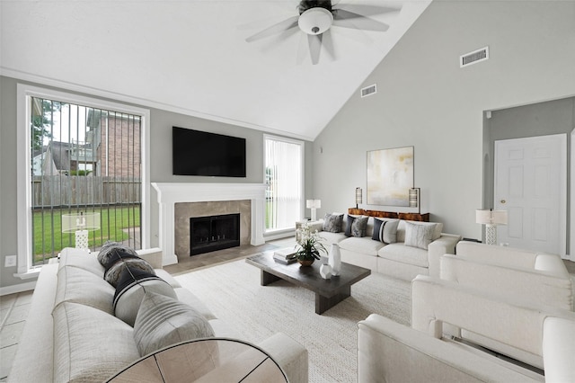 living room featuring a fireplace, high vaulted ceiling, plenty of natural light, and ceiling fan