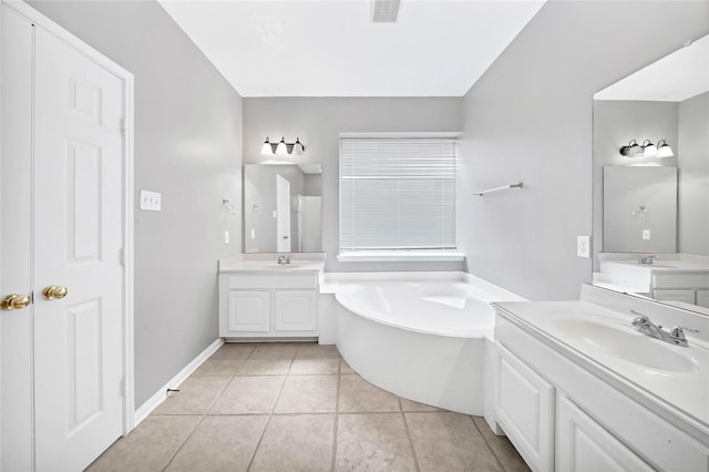 bathroom with a bathing tub, tile patterned flooring, and vanity