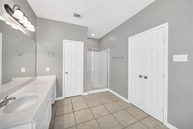 bathroom featuring tile patterned flooring, vanity, and an enclosed shower